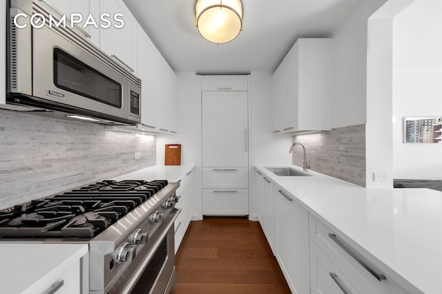 kitchen featuring stainless steel appliances, a sink, light countertops, and white cabinets