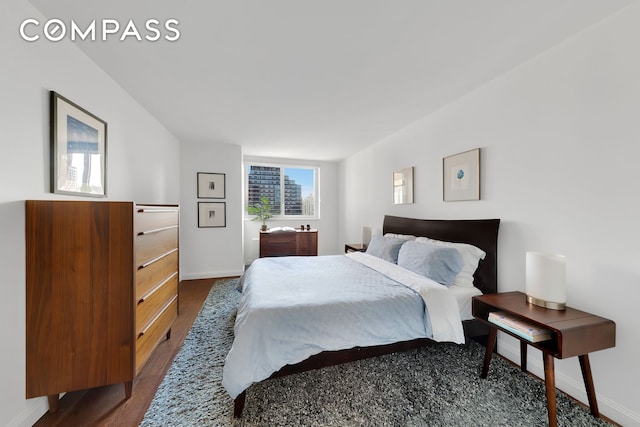 bedroom with baseboards and wood finished floors