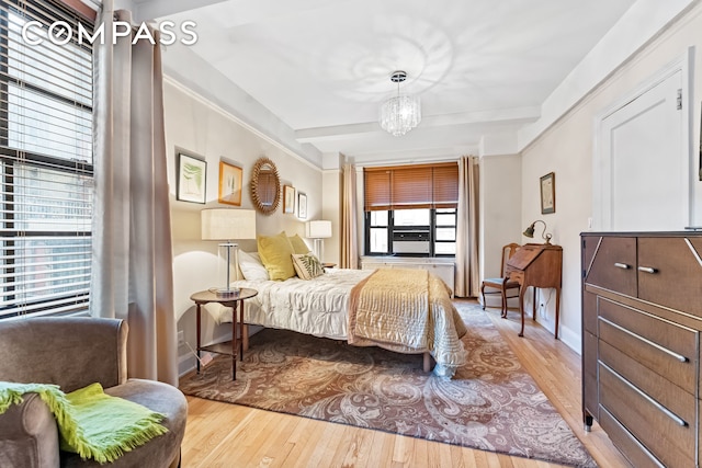 bedroom with hardwood / wood-style floors, a notable chandelier, and baseboards