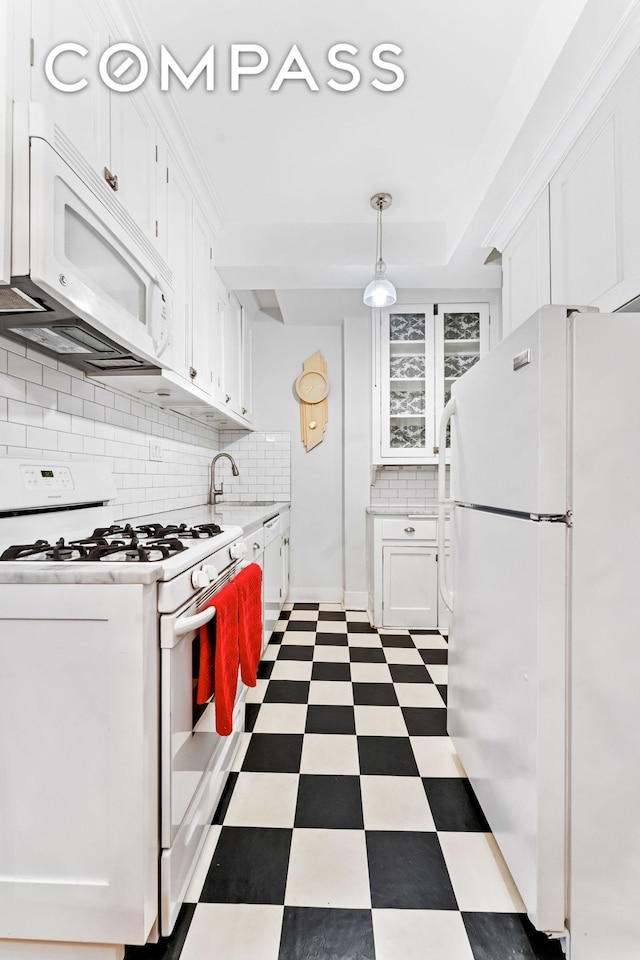 kitchen with tile patterned floors, white appliances, white cabinets, and light countertops