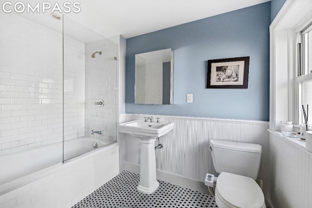 bathroom with toilet and tiled shower / bath combo