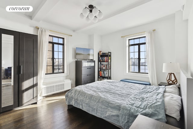 bedroom with beam ceiling, dark hardwood / wood-style floors, and a wall mounted air conditioner