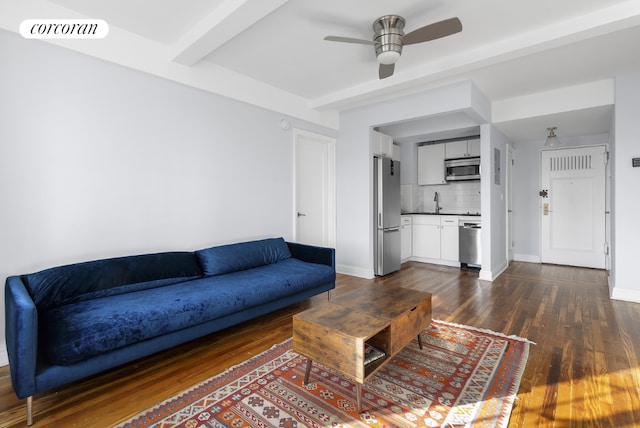 living room with ceiling fan, beam ceiling, and dark hardwood / wood-style floors