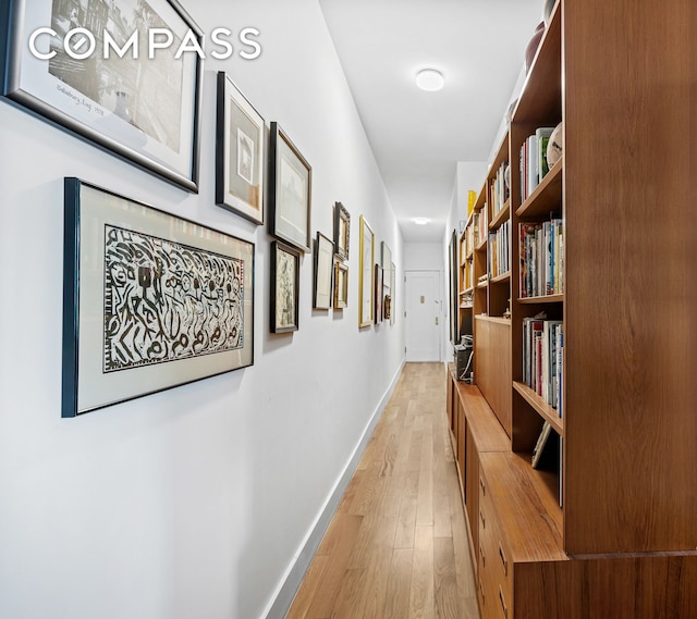 hallway with light wood-style flooring and baseboards