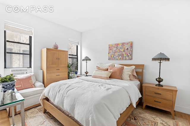 bedroom with cooling unit and light wood-style flooring