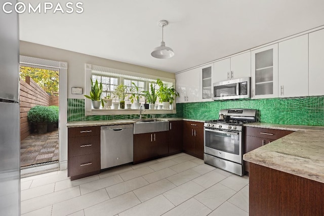 kitchen featuring pendant lighting, sink, white cabinetry, appliances with stainless steel finishes, and dark brown cabinets