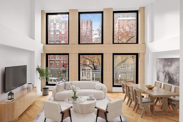 living room featuring a towering ceiling and light parquet flooring