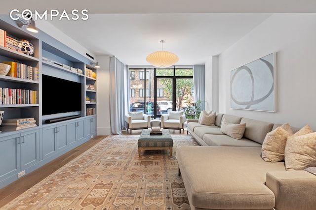 living room with a wall of windows and light wood-style floors