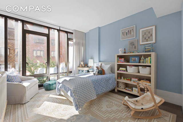 bedroom with a wall of windows and baseboards