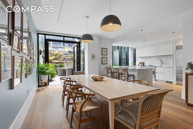 429 Kent Ave Unit Th2, New York City, NY 11249 - dining area featuring light wood-style floors, a wall of windows, and baseboards