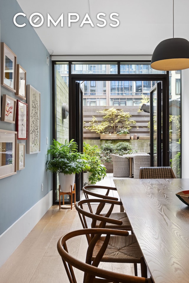 429 Kent Ave Unit Th2, New York City, NY 11249 - dining space featuring a wall of windows, light wood-type flooring, and baseboards