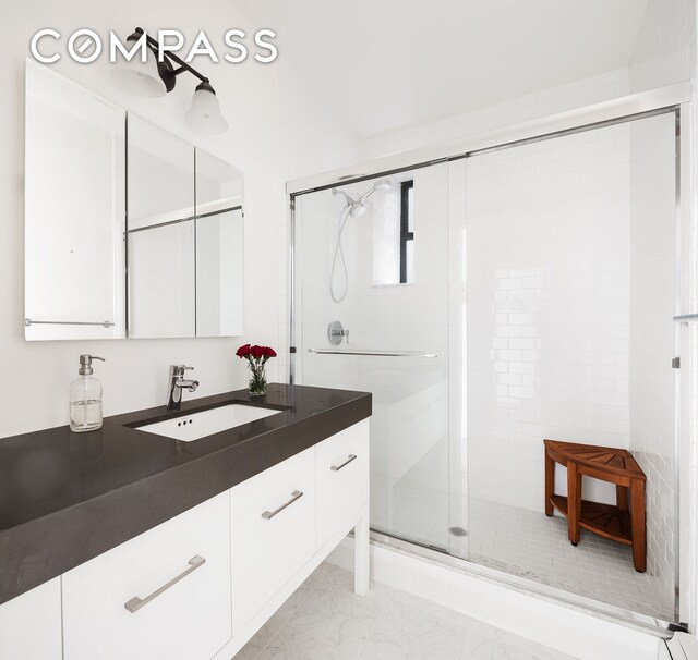 bathroom featuring vanity and an enclosed shower