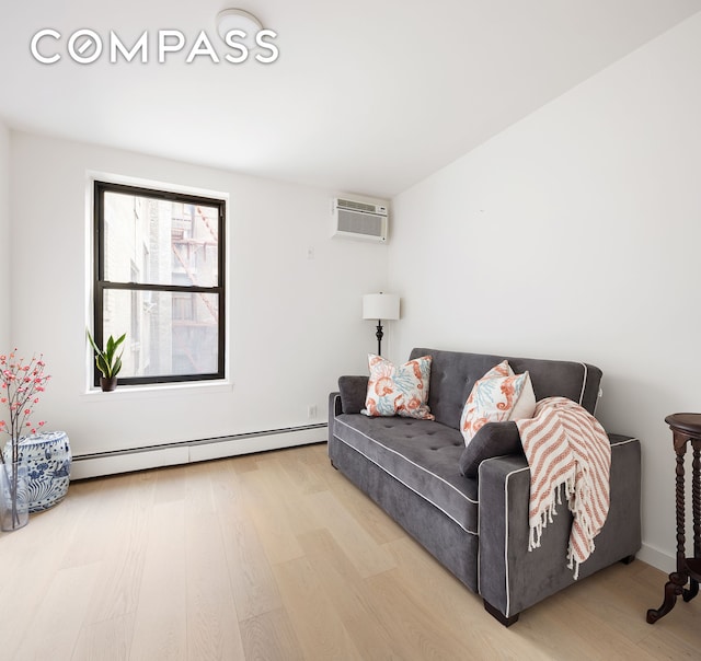 living room featuring a wall unit AC, wood finished floors, and baseboard heating