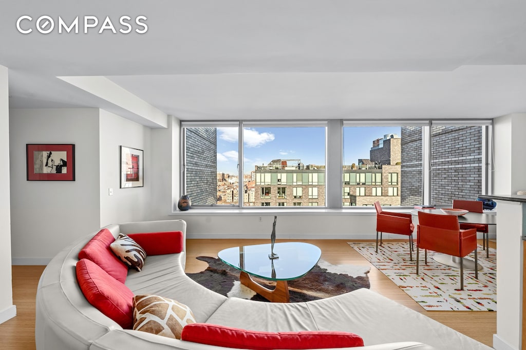 living area with a view of city, wood finished floors, and baseboards