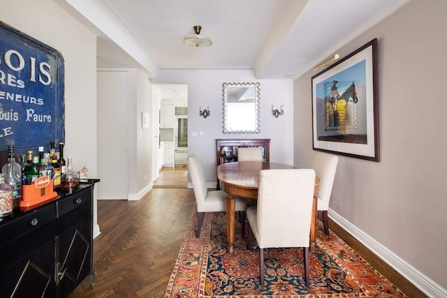 dining area featuring ornamental molding and dark parquet floors