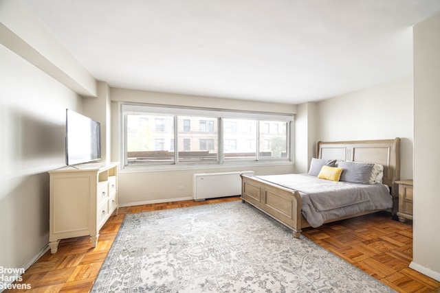 bedroom featuring light parquet flooring and radiator