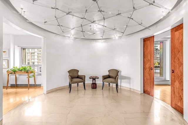 living area with marble finish floor, plenty of natural light, and baseboards