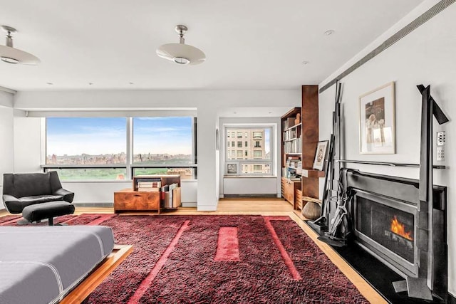 living area featuring light wood finished floors and a fireplace with flush hearth