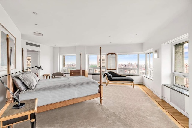 bedroom with light wood-type flooring, multiple windows, and baseboards