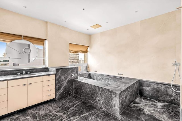 full bath with marble finish floor, vanity, and a bath