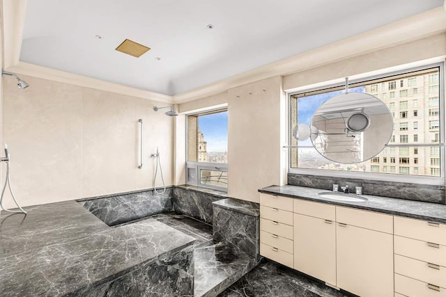 bathroom with marble finish floor, a shower, and vanity