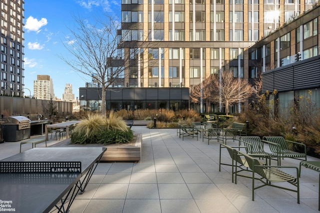 view of property's community featuring a patio area, a view of city, and exterior kitchen