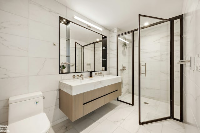 202 Broome St Unit 7L, New York City, NY 10002 - bathroom featuring double vanity, a marble finish shower, toilet, tile walls, and marble finish flooring