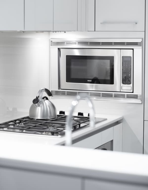 interior details featuring stainless steel microwave and white cabinets