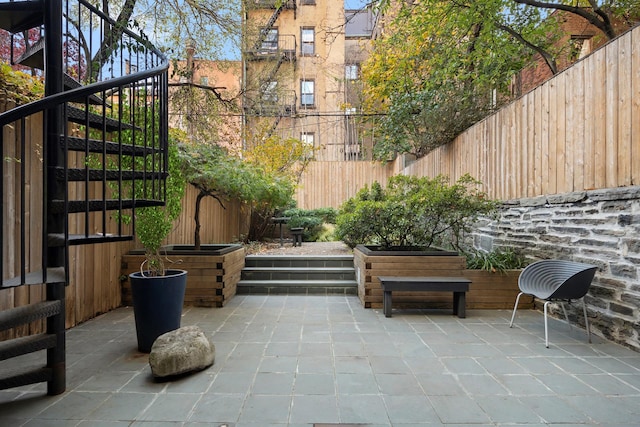 view of patio / terrace featuring a fenced backyard and stairs