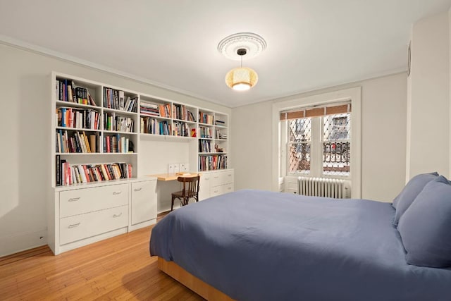 bedroom with radiator and light wood-type flooring