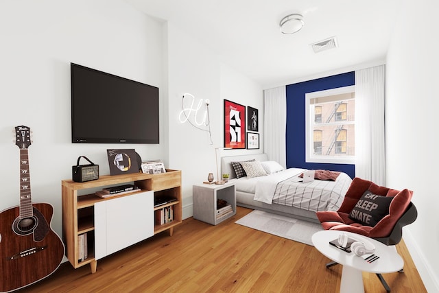 bedroom with light wood-style floors and visible vents