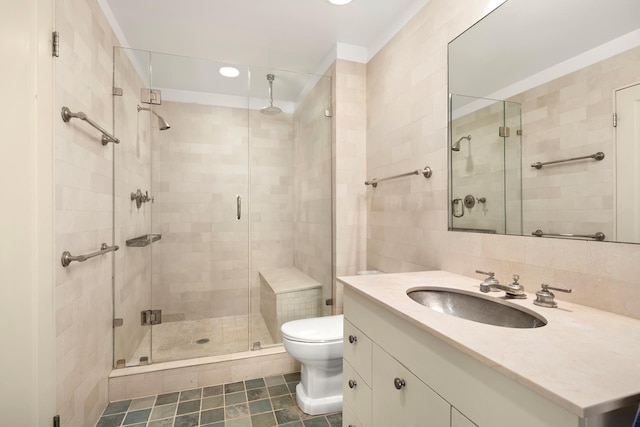 bathroom with a stall shower, toilet, tile patterned floors, vanity, and tile walls