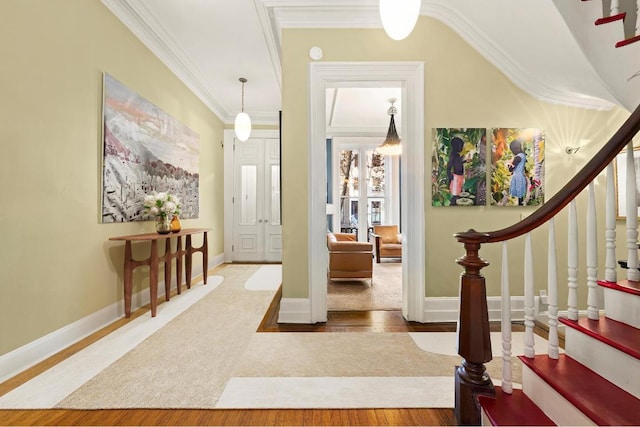 entrance foyer featuring ornamental molding and hardwood / wood-style flooring