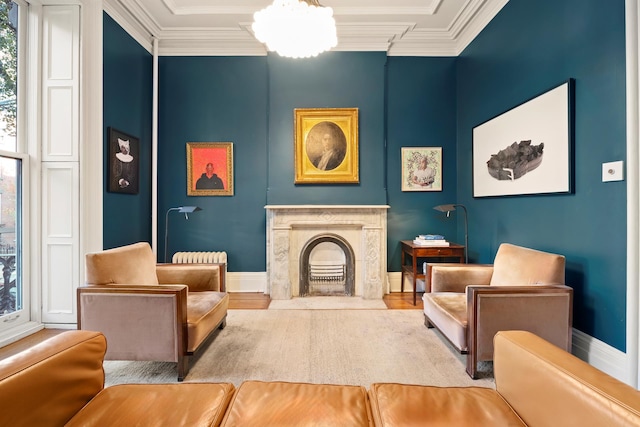 sitting room with ornamental molding, wood finished floors, and a high end fireplace