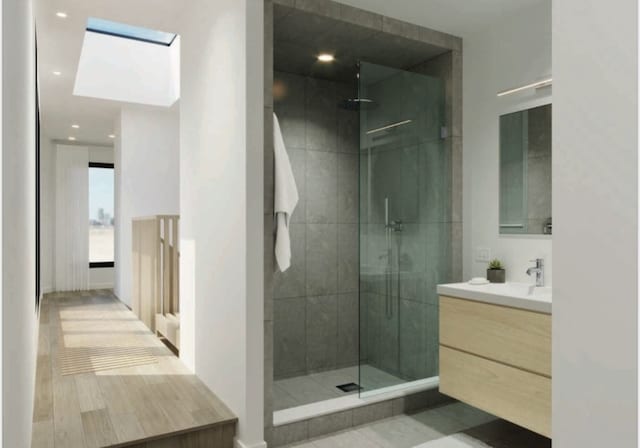 bathroom featuring tiled shower and vanity