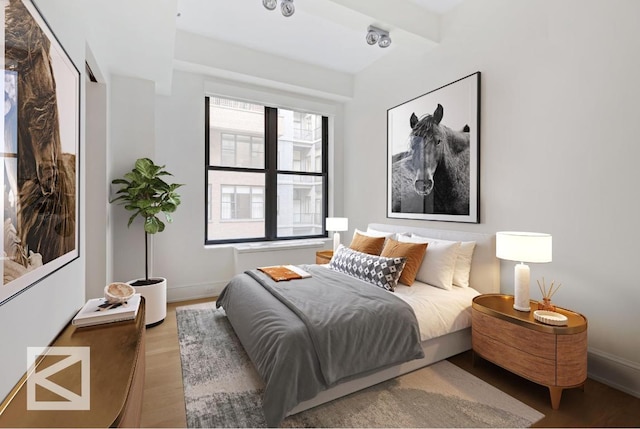 bedroom featuring wood-type flooring and beamed ceiling