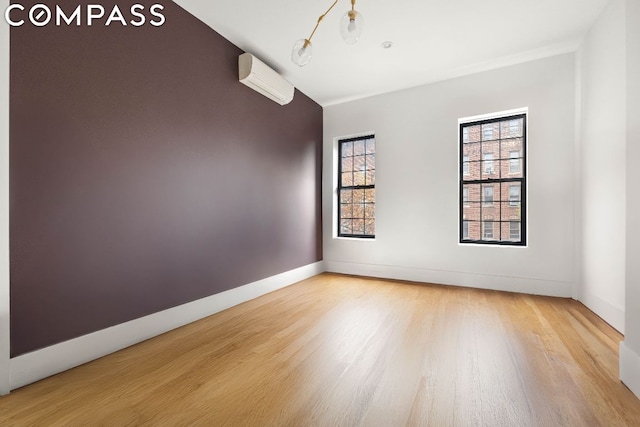 spare room with hardwood / wood-style flooring and a wall unit AC