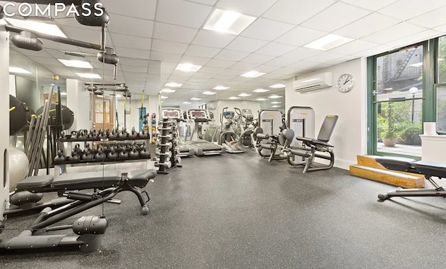 workout area featuring a drop ceiling and a wall mounted air conditioner