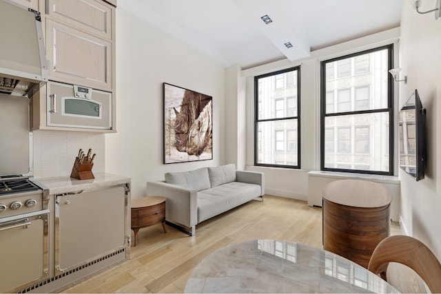 sitting room with beam ceiling and light wood-style flooring