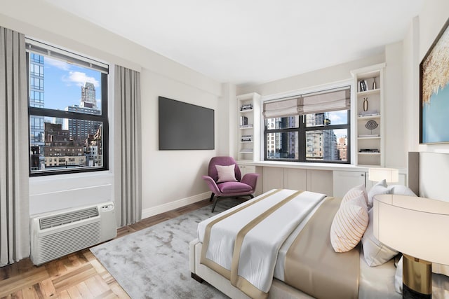 bedroom with a wall unit AC and baseboards