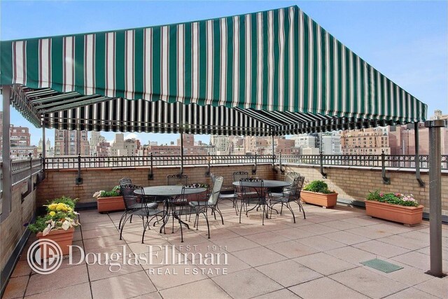 view of patio / terrace with outdoor dining area, visible vents, and a city view