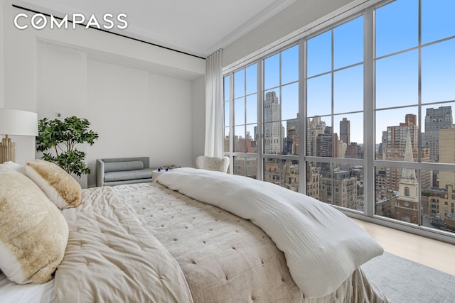 bedroom with a view of city and wood finished floors