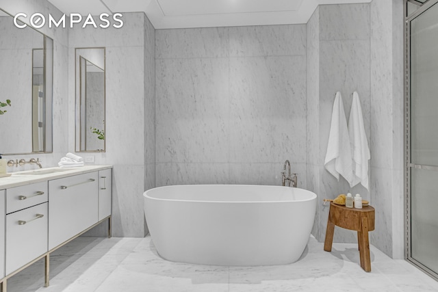 bathroom featuring vanity, marble finish floor, and a freestanding bath