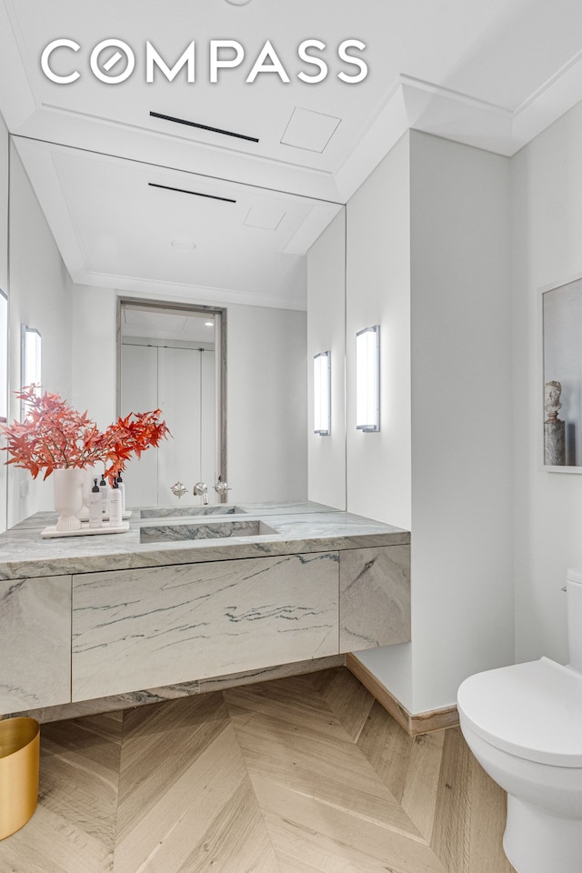 bathroom with plenty of natural light, toilet, vanity, and crown molding