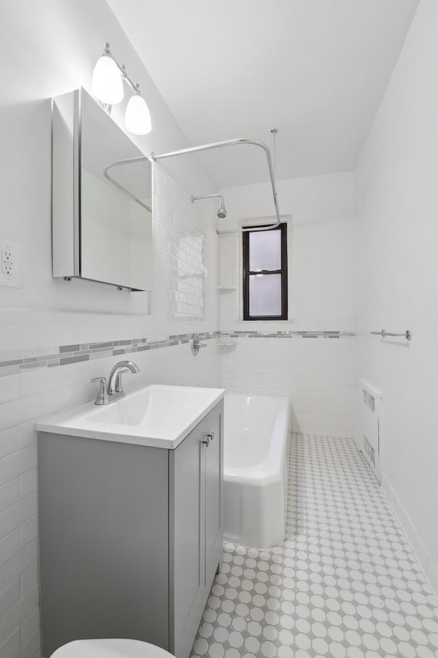 full bathroom with toilet, vanity, and tile walls