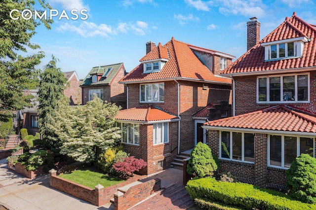 139 82nd St, New York City, NY 11209 - view of front facade with a chimney, brick siding, and a tile roof