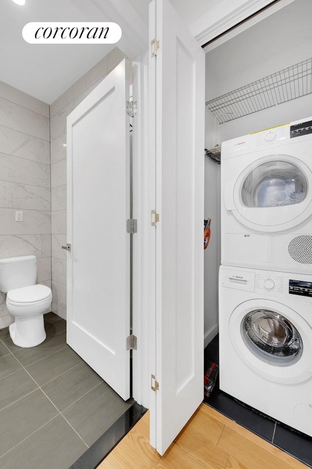 21-17 31st Ave Phe, Phe, New York City, NY 11106 - washroom featuring tile walls, stacked washer / drying machine, laundry area, and light wood-style floors