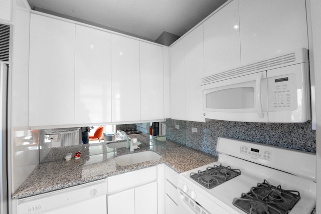 kitchen featuring white appliances, a sink, light stone countertops, and white cabinets