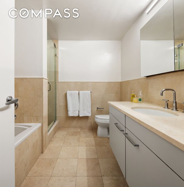 kitchen with white cabinetry, appliances with stainless steel finishes, washer / dryer, and sink