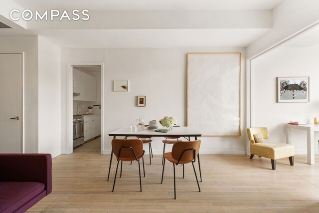 dining space with sink and light hardwood / wood-style floors